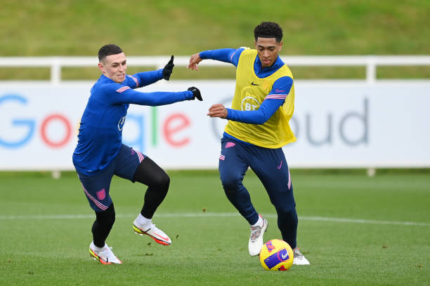 Jude Bellingham and Phil Foden of England battle for the ball during a training session at St George's Park on November 09, 2021 in Burton upon...