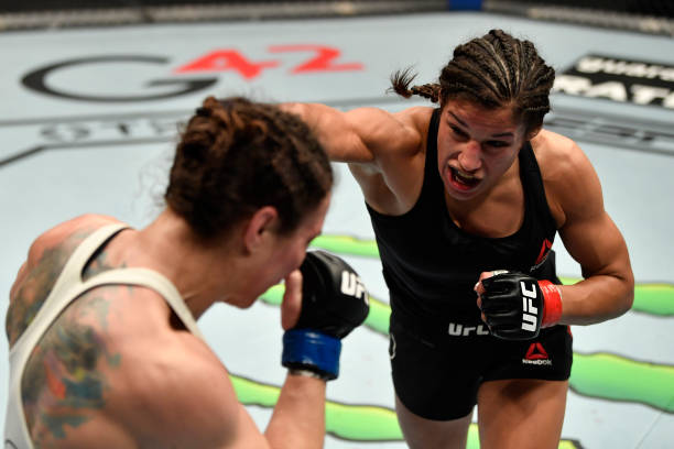 Julianna Pena punches Sara McMann in a bantamweight fight during the UFC 257 event inside Etihad Arena on UFC Fight Island on January 23, 2021 in Abu...