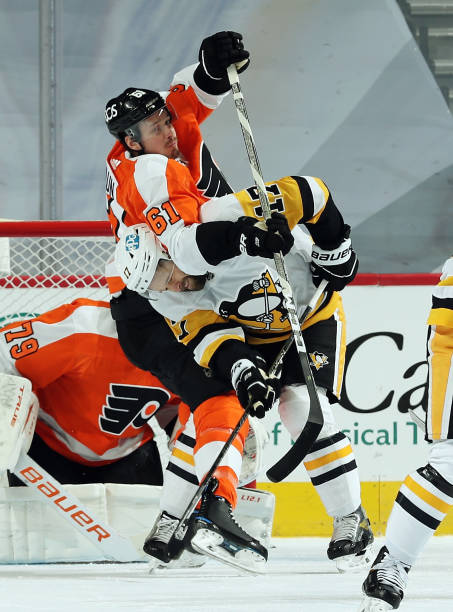 Justin Braun of the Philadelphia Flyers battles in front of Carter Hart with Bryan Rust of the Pittsburgh Penguins on January 13, 2021 at the Wells...