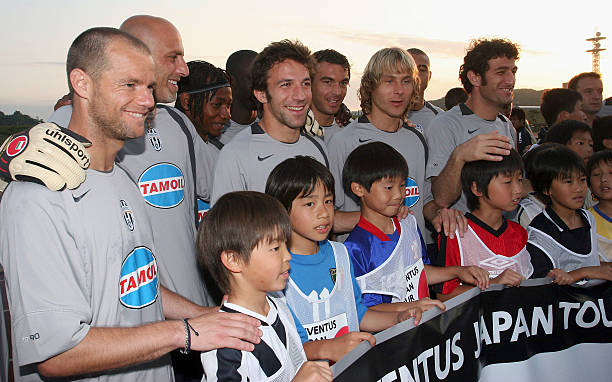 Juventus players pose with Japanese soccer fans during a junior soccer school run by Juventus at Nissan Stadium on May 31, 2005. Juventus will play...