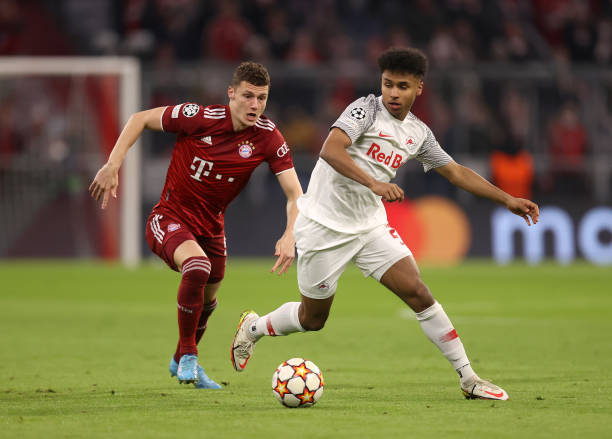 Karim Adeyemi of FC Red Bull Salzburg runs with the ball under pressure from Benjamin Pavard of FC Bayern Muenchen during the UEFA Champions League...