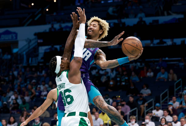 Kelly Oubre Jr. #12 of the Charlotte Hornets drives against Marcus Smart of the Boston Celtics during the first half of their game at Spectrum Center...