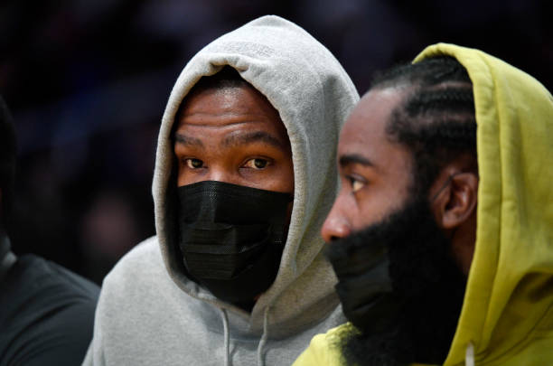 Kevin Durant and James Harden of the Brooklyn Nets follow the action from the bench during a preseason game against the Los Angeles Lakers at Staples...