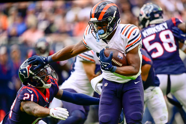 Khalil Herbert of the Chicago Bears rushes for a first down in the fourth quarter against Steven Nelson of the Houston Texans at Soldier Field on...