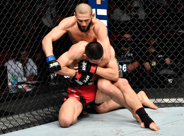 Khamzat Chimaev of Sweden punches Li Jingliang of China in a welterweight fight during the UFC 267 event at Etihad Arena on October 30, 2021 in Yas...