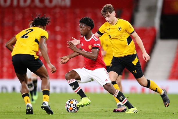 Kobbie Mainoo of Manchester United is challenged by Harvey Griffiths and Dexter Lembikisa of Wolverhampton Wanderers during the FA Youth Cup Semi...