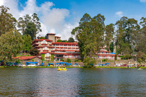 kodaikanal, south india - looking from kodaikanal lake towards the carlton hotel, in the colonial town, in the state of tamil nadu; several tourists' cars are parked by the lakeside. - kodaikanal stock pictures, royalty-free photos & images