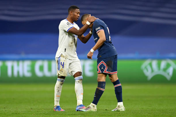 Kylian Mbappe of Paris Saint-Germain is consoled by David Alaba of Real Madrid following the the UEFA Champions League Round Of Sixteen Leg Two match...