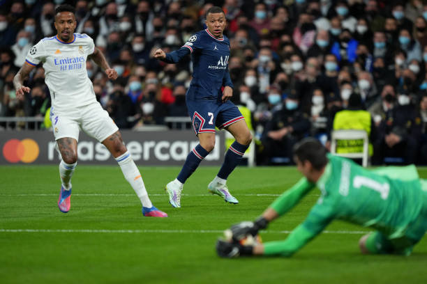 Kylian Mbappe of Paris Saint-Germain shoots towards goal as Thibaut Courtois of Real Madrid makes a save during the UEFA Champions League Round Of...