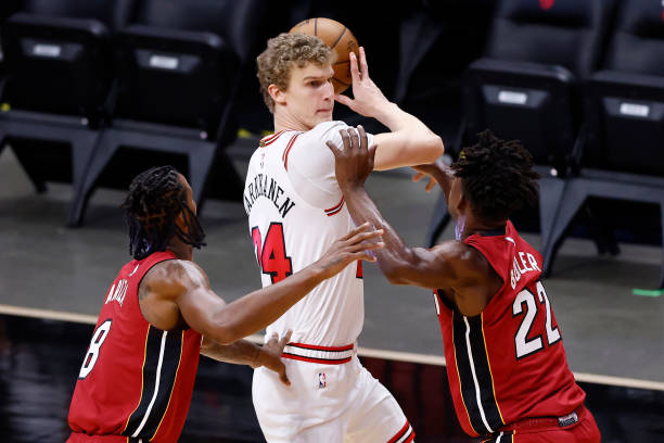Lauri Markkanen of the Chicago Bulls is defended by Trevor Ariza and Jimmy Butler of the Miami Heat during the first quarter at American Airlines...