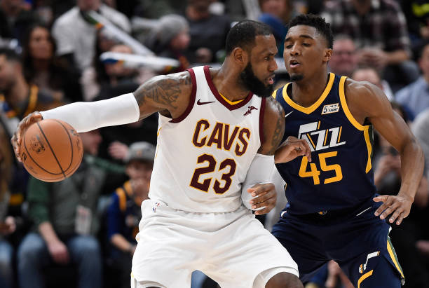 LeBron James of the Cleveland Cavaliers is defended by Donovan Mitchell of the Utah Jazz in the second half of the 104-101 win by the Utah Jazz at...