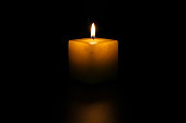 Lit candle with neutral black background