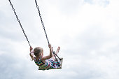 Little child swinging on a wooden swing