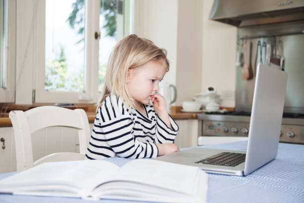 little girl learning with a computer - nail biting in children stock pictures, royalty-free photos & images