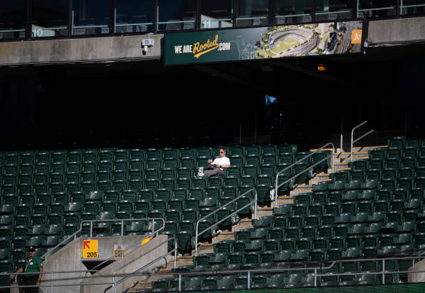 Lone Oakland Athletics fan sits in the empty stands in the first inning of their MLB game against the Toronto Blue Jays at the Coliseum in Oakland,...