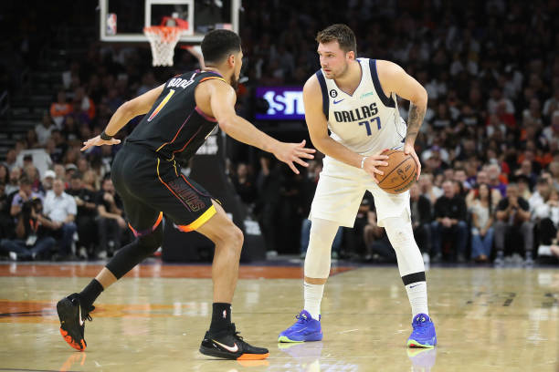 Luka Doncic of the Dallas Mavericks handles the ball against Devin Booker of the Phoenix Suns during the first half of the NBA game at Footprint...