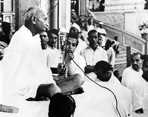 Mahatma Gandhi surrounded by his assistants and followers, giving a speech on independence of India on March 24, 1946 in Bombay, India.