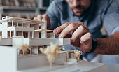 Male architect hands making model house