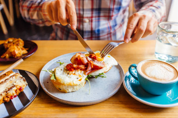 man eating breakfast with egg bacon arugula on brioche bun and coffee picture id1014138304?k=20&m=1014138304&s=612x612&w=0&h= kukZxYyQwt2Itp0Byk9rSU9n aR RZc9kUdf234IAo=