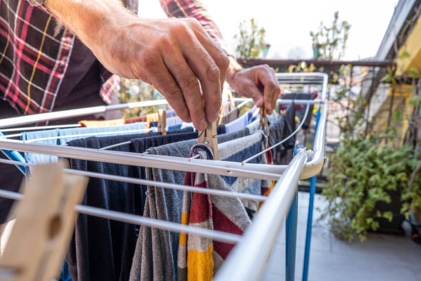 homem pendurando roupas na linha de roupas ao ar livre - varal de roupa - fotografias e filmes do acervo