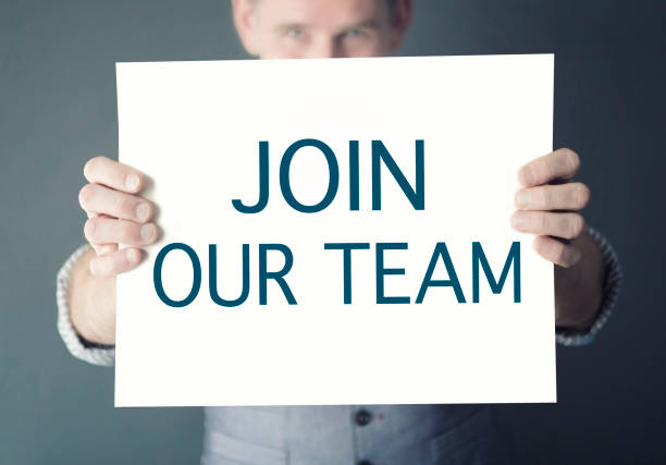 man holding sign with words Join Our Team