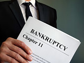 Man holds Bankruptcy Chapter 11 agreement documents.