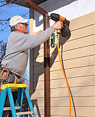 Man installing siding with nail gun