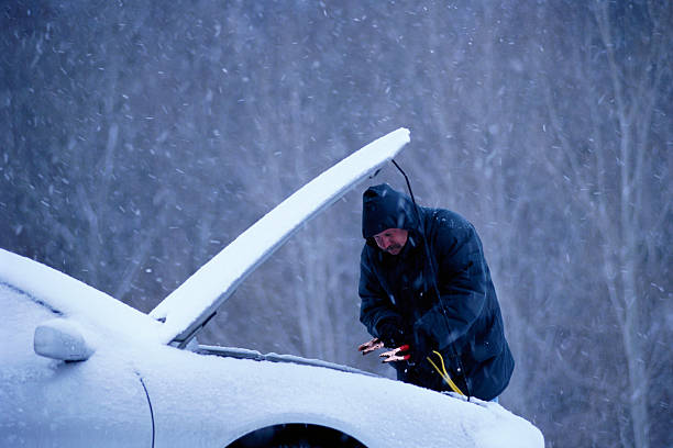 man jump starting car in snow - bateria de carro - fotografias e filmes do acervo