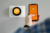 Man uses a mobile phone with smart home app in modern living room