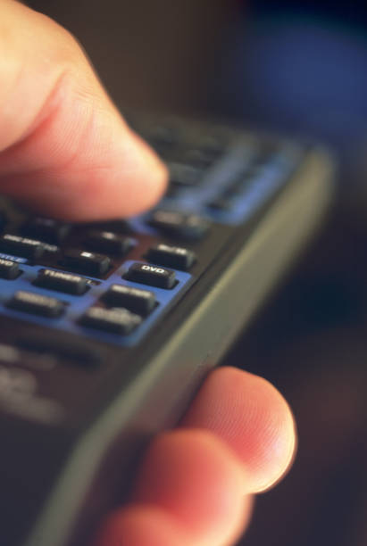 Man using remote control. close-up (focus on DVD button)