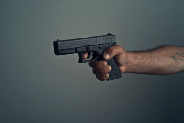 man with gun - a hand holding a gun stock pictures, royalty-free photos & images
