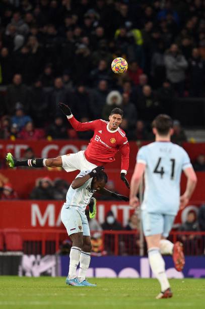 Manchester United's French defender Raphael Varane jumps to head the ball over West Ham United's English midfielder Michail Antonio during the...