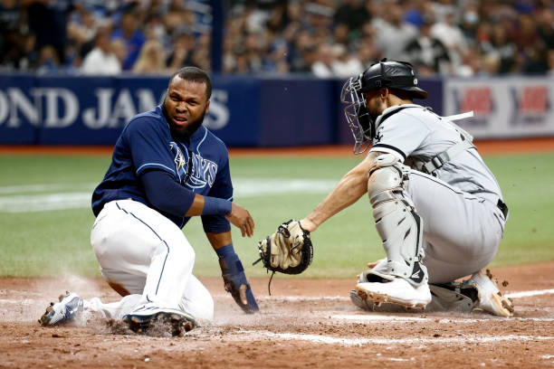 Manuel Margot of the Tampa Bay Rays slides safely into home plate on a sacrifice fly from the bat of Kevin Kiermaier as Seby Zavala of the Chicago...