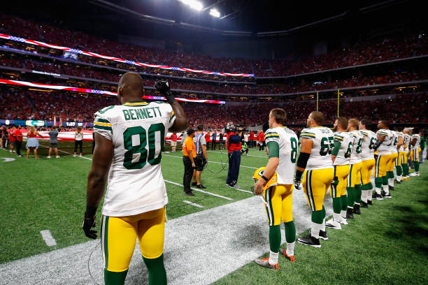 Martellus Bennett of the Green Bay Packers raises his fist during the national anthem prior to the game between the Green Bay Packers and the Atlanta...