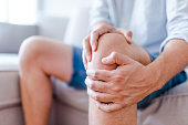 A mature man massaging his painful knee