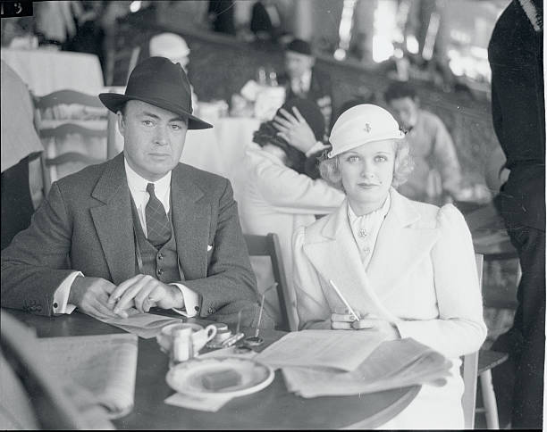 Mexico: Stars At Mexican Track. Joan Bennett, motion picture actress, and her husband, Gene Markey, popular writer; view the running of the Agua...
