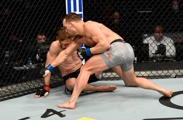 Michael Chandler punches Dan Hooker of New Zealand in a lightweight fight during the UFC 257 event inside Etihad Arena on UFC Fight Island on January...