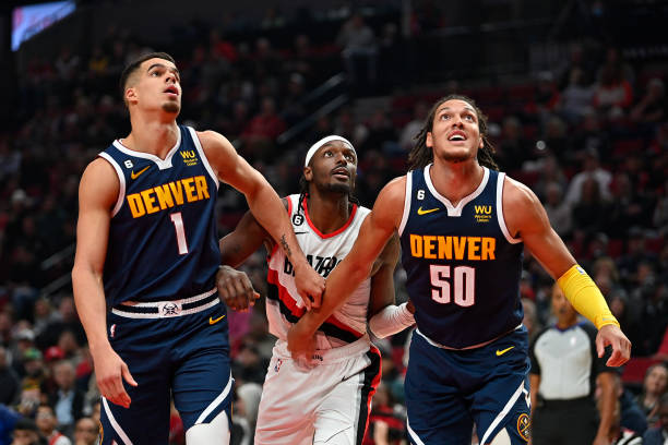 Michael Porter Jr. #1 and Aaron Gordon of the Denver Nuggets look for a rebound against Jerami Grant of the Portland Trail Blazers during the first...
