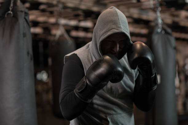Media formación de años pelirroja guapo boxeador luchador con pesado bolso en gimnasio