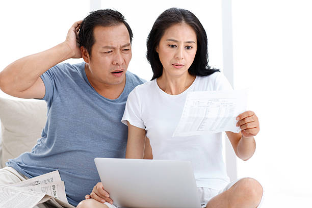 middle-aged couples in the look at the bill - confused asian couple stock pictures, royalty-free photos & images
