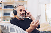 Middle-aged man listening to music online at home