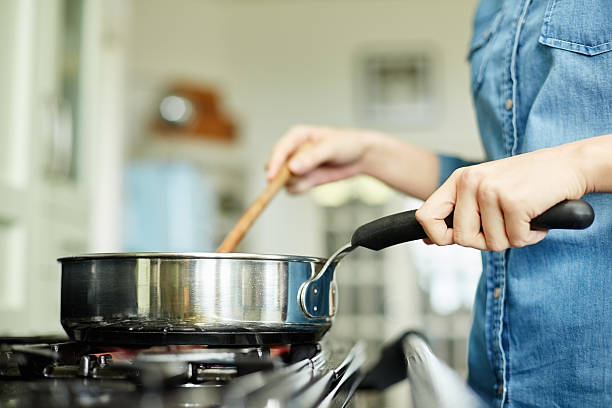 midsection image of woman cooking food in pan - a hand of a woman holding a food stock pictures, royalty-free photos & images