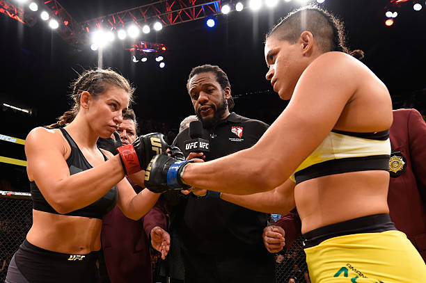 Miesha Tate and Amanda Nunes of Brazil touch gloves in their UFC women's bantamweight championship bout during the UFC 200 event on July 9, 2016 at...
