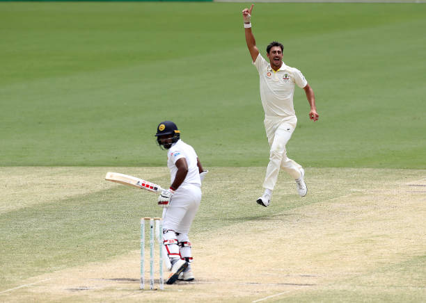 Mitchell Starc of Australia celebrates after taking the wicket of Kusal Perera of Sri Lanka during day four of the Second Test match between...