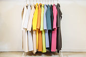 Mix color row of female coats on hangers.