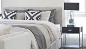 Modern Gray tone bedding and bedside table and lamp in black