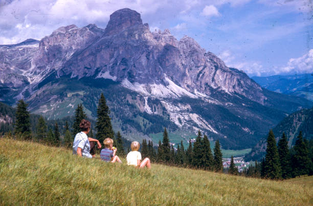 mother and children sat in field in Dolomite Mountains, 1960s