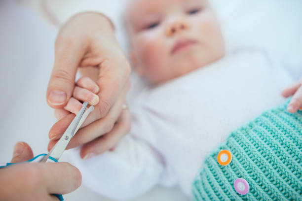 mother cutting finger nails of her baby girl. - cutting baby nails stock pictures, royalty-free photos & images