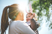 Mother holding child with bunny ears