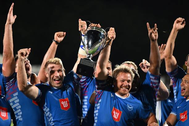 TOPSHOT - Namibia's players celebrate with the trophy after winning the Rugby Africa Cup rugby union final match between Namibia and Kenya at the Maurice David Stadium in Aix-en-Provence, southeastern France, on July 10, 2022. (Photo by CHRISTOPHE SIMON / AFP) (Photo by CHRISTOPHE SIMON/AFP via Getty Images)
